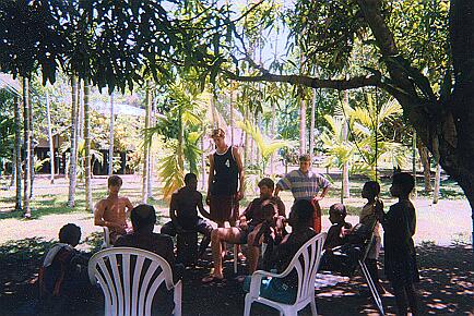 The extended family sitting under the mango tree